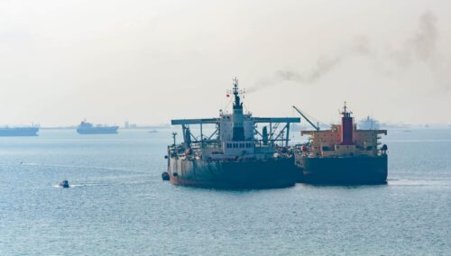 Loading anchored oil supertanker via a ship to ship oil transfer